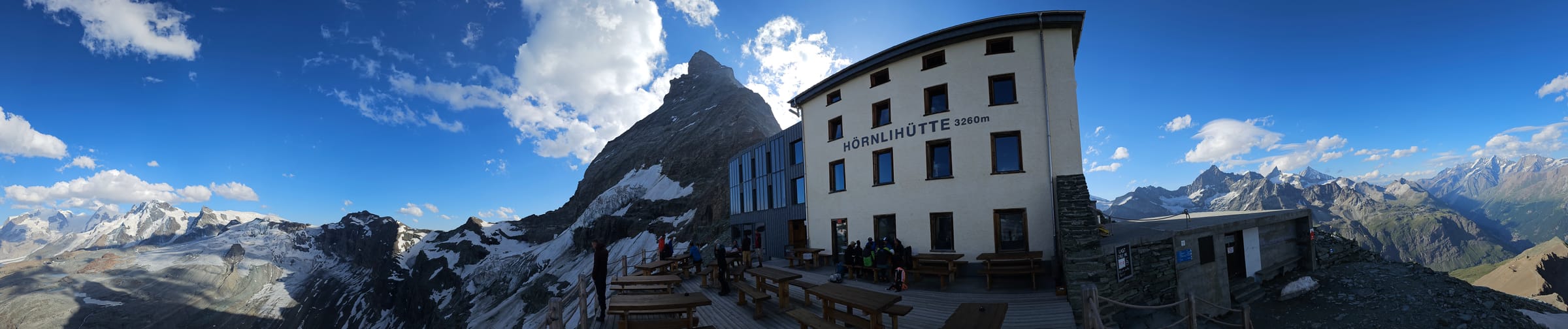 Ultra wide panorama of the H&ouml;rnlih&uuml;tte terrace at 3260m with the Matterhorn rising behind it