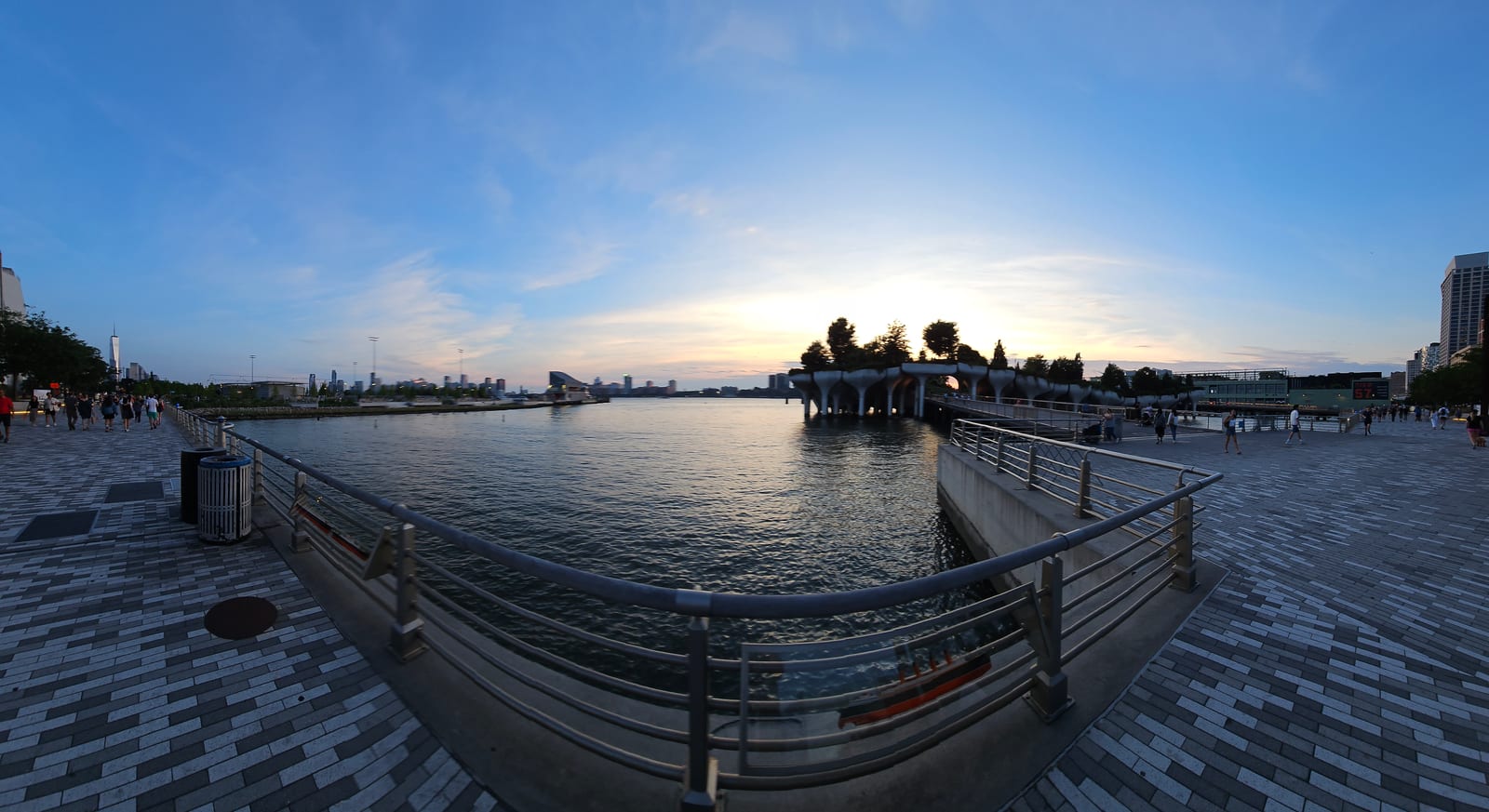 Wide panorama of the Hudson River boardwalk at sunset, Little Island on its tulip shaped piers