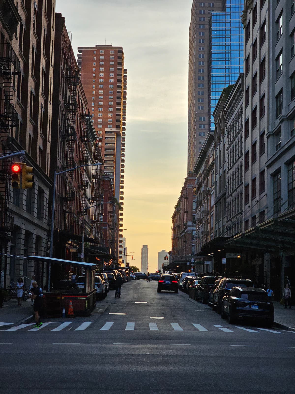 A Tribeca street at sunset, the sky glowing yellow between the towers at the end of the block
